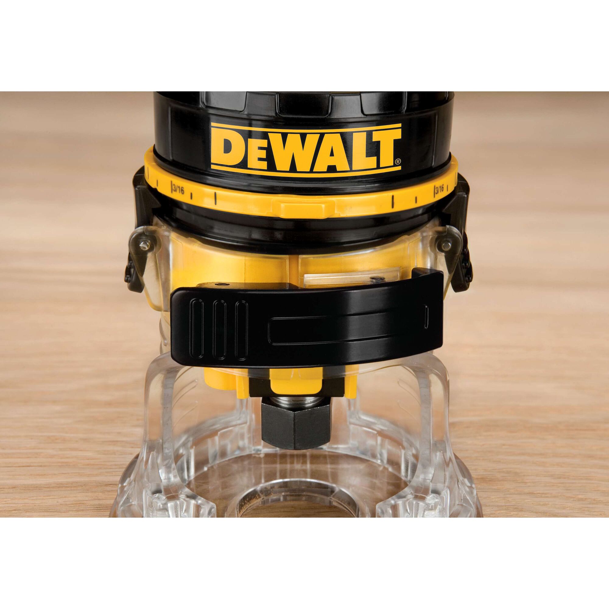 Close-up image of a DEWALT DWE6000 wood router showing the base and adjustment mechanisms on a wooden surface.