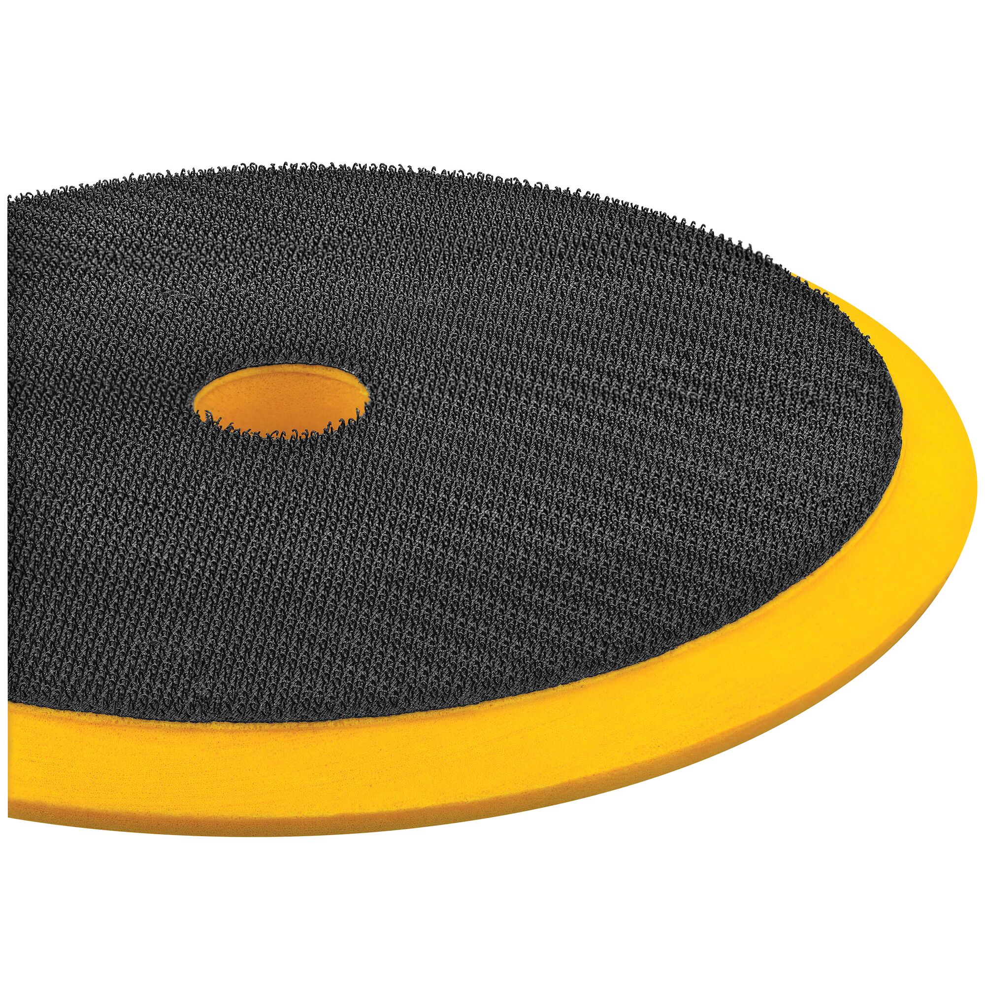Close-up view of a DEWALT circular polishing pad with a textured black surface and a central hole, featuring a yellow foam backing.